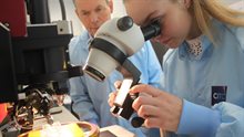 Student looking through wirebonder microscope