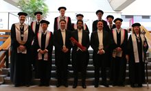 roup of professors surrounding PhD candidate who was just awarded his PhD degree