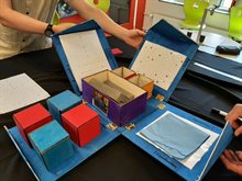 A home-made puzzle box lies open on a table showing several assignments about chip packaging