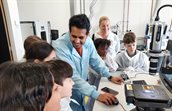 Researcher surrounded by children during a lab visit