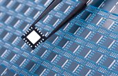 Chip between tweezers with a leadframe as background